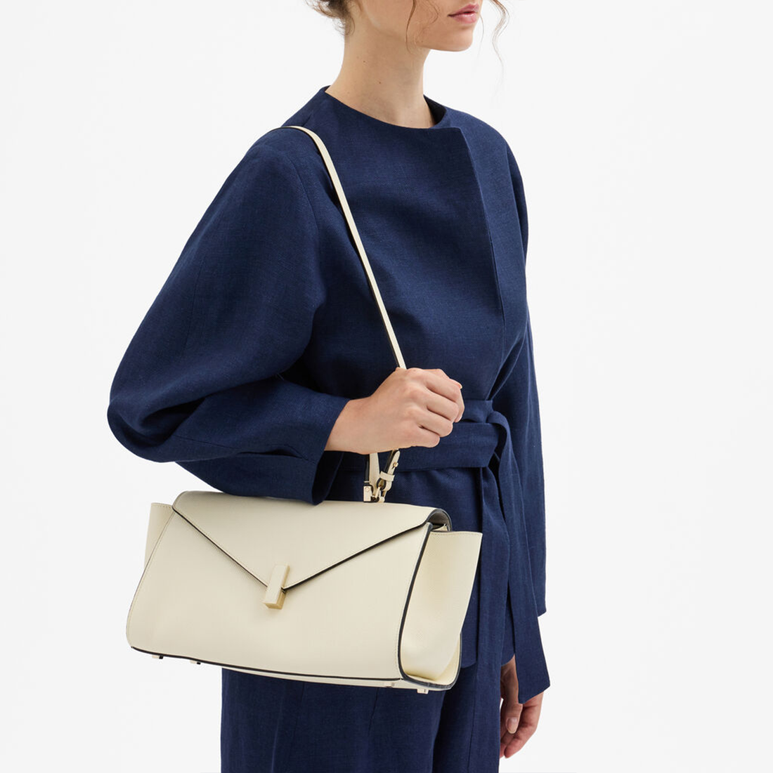 Soft Parchment Off-White Elongated Envelope Geometric Hand Bag With Rectangular Metallic Flap Clasp, Contrast Curved Top Handle And Slim Matching Shoulder Strap